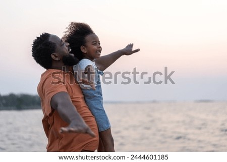 African love family father and daughter enjoying a carefree moment  strength and happiness as he lifts his young daughter, childhood, joy, leisure, parenting and outdoor activities, Father day Royalty-Free Stock Photo #2444601185