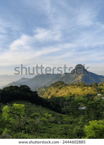A breathtaking vista of rolling hills and distant mountains, bathed in the soft light of dawn Royalty-Free Stock Photo #2444602885