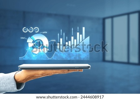 Close up of hand holding tablet with creative digital business pie chart on blurry office interior background. Glowing stock market analysis and big business data analysis