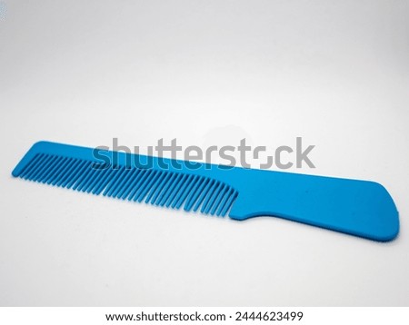 close up selective focus of blue hair comb isolated on white background