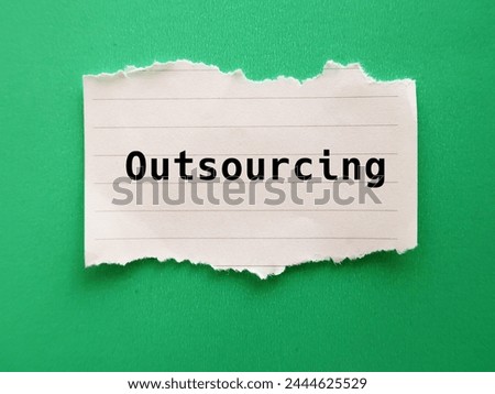 Torn paper on green background with word - Outsourcing - practice used by business to reduce costs by transferring portions of work to outside suppliers or outsource Royalty-Free Stock Photo #2444625529