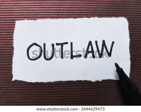 Outlaw writting on brown background. Royalty-Free Stock Photo #2444629473