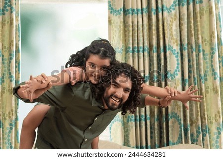 Father and daughter playing together at home during leisure time on Father's day