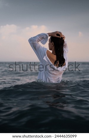 Girl swims in the sea, epitomizing calmness and relaxation. Promotes tourism, resorts, healthy lifestyle, and outdoor sports.