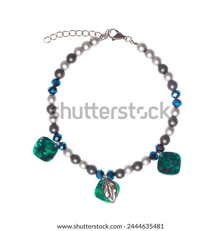 Green and blue jewelry necklace with semiprecious stones, pearl and gold chain isolated on white background Royalty-Free Stock Photo #2444635481