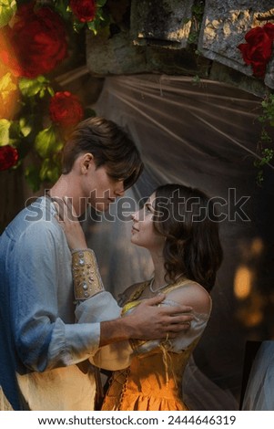 a guy and a girl in love hug among flowers and candles. vintage romantic picture