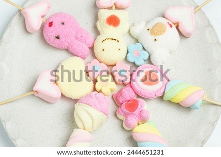 Top view Masmelo, cute cartoon shape, colorful, sweet, delicious, chewy, in a white plate, birthday gift for girls.