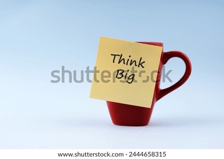 Think big text on adhesive note stick on a coffee cup