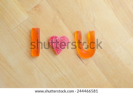Orange letters and a red gummy heart display the message I love You