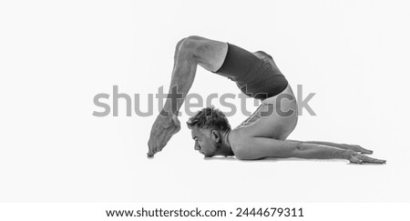 Ganda bherundasana, Ashtanga yoga  Side view of man wearing sportswear doing Yoga exercise against white background.  Black and white image. Copy space for text or design.