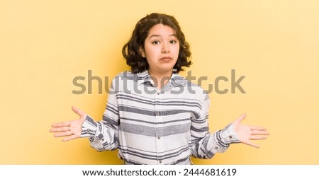 pretty hispanic woman feeling puzzled and confused, unsure about the correct answer or decision, trying to make a choice