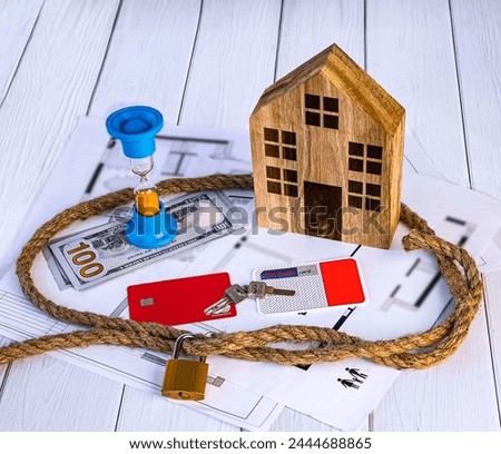 Home loan concept. Wooden house, rope knot, hourglass, house keys, dollar bills, credit cards on white background.