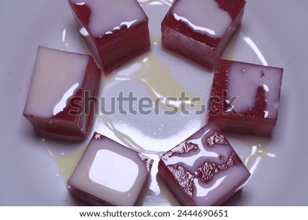 a red caramel pudding with a rounded shape on the beautifull white plate, the picture taken with close up viewed
