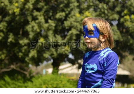 Little boy in a superhero costume and mask. Costume party, carnival, masquerade, Halloween, Purim.