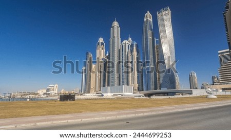 Scenic view of Dubai Marina tallest Skyscrapers with boats timelapse hyperlapse, Skyline, View from sea, United Arab Emirates. Blue sky at sunny day and traffic on the road Royalty-Free Stock Photo #2444699253