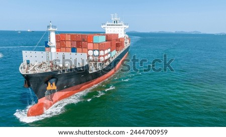 Aerial side view of cargo ship with contrail in the ocean sea ship carrying container and running from container international port smart freight shipping by ship service	

