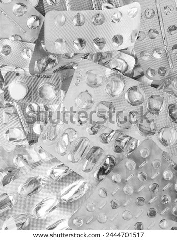 A pile of used silver blisters. Empty pill blister packs. Medicine packs background. Treatment and medication concept Royalty-Free Stock Photo #2444701517
