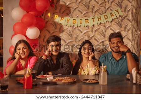 Friends enjoying a meal at restaurant during birthday celebration
