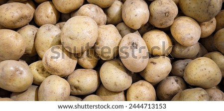 "Display of stacked potatoes in a supermarket aisle. Fresh and nutritious produce available for shoppers. Concept of healthy eating and grocery shopping."