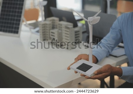 Close-up at tablet, Engineers pointing at tablet with their hands. To jointly design the use of renewable energy with wind and solar energy. Concept of using renewable energy.