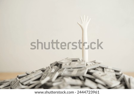 Need help arm on US dollar bill banknotes pile with white wall background. Business bankruptcy, personal loan high interest rate, burden of consumer debt, overdue payment, financial crisis concept. Royalty-Free Stock Photo #2444723961