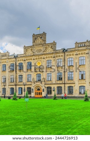 It's a photo of green lawn in front of main building of National Technical University of Ukraine. Its view of Igor Sikorsky Kyiv Polytechnic Institute. It's sunny day with cloudy sky