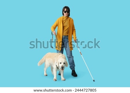 Blind woman with guide dog on blue background Royalty-Free Stock Photo #2444727805