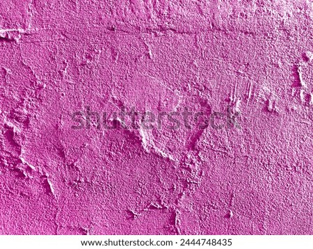 Bright pink stucco on a concrete wall with a subtle love heart shape creating a beautiful organic texture for an abstract background