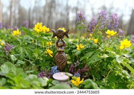 amulet of Triple Goddess with candle on floral meadow, natural background. Symbol of the Triune Moon. esoteric ritual for Beltane. witch, wiccan spiritual practice for relax, harmony Royalty-Free Stock Photo #2444753605