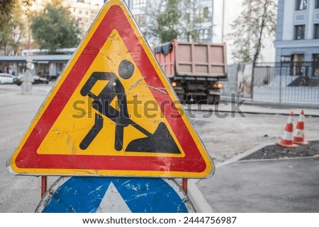 Metal sign "under construction" on the background of construction work