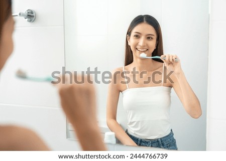 Young smiling asian woman holding brush teeth for the health of teeth in restroom. Take care and good dental health fresh breath Royalty-Free Stock Photo #2444766739