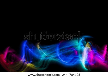 Abstract colorful irregular lines on black background and wall texture. Long exposure. Light painting photography.