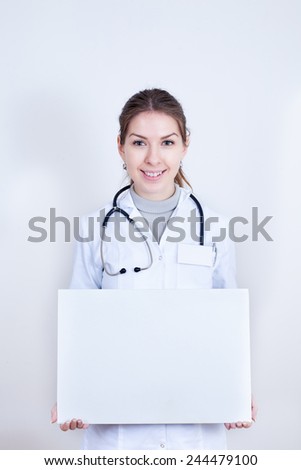 Smiling doctor holding a banner for advertising
