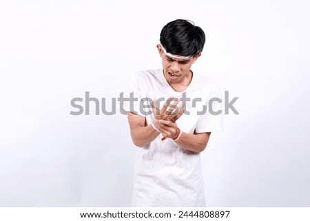 Young asian boy with red white ribbon celebrating Indonesia independence day while feeling painful with his palm