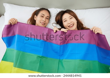 women or couples using rainbow flag cover their body on bed, LGBT concept