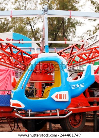 old aged colorful riding capsule in form of helicopter airplane toys in a playground as circus carousel in a country fair in BANGKOK THAILAND.