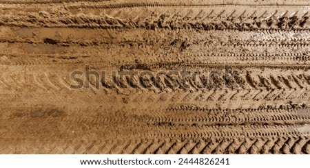 view from above on texture of wet muddy road with puddle and tractor tire tracks in countryside Royalty-Free Stock Photo #2444826241