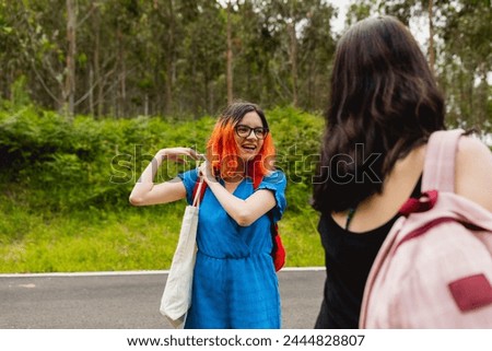 Two girls chat animatedly before starting a walk in a rural area close to nature, in summer