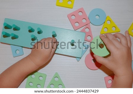 Baby hands play wooden educational teaching aids Intelligence game Preschool Top view Close up Eyes coordination Cognitive skills concept Child logical development Wooden colorful blocks Education 