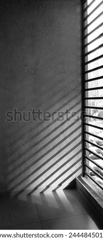 Abstract background on Parallel diagonal black and white gradient lines. Sun shutters shadow on plaster wall. Light and shade play from window at home. tiled floor