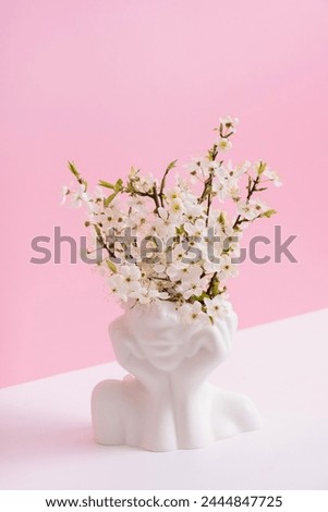 Head shape vase with spring bloom on pink background. Spring inspiration, mental health concept. Royalty-Free Stock Photo #2444847725