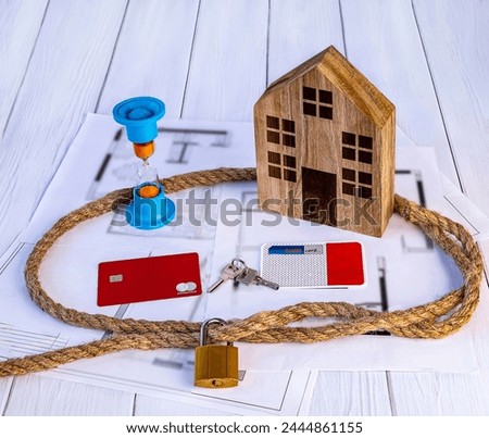 Home loan concept. Wooden house, rope knot, hourglass, house keys, credit cards on white background.
