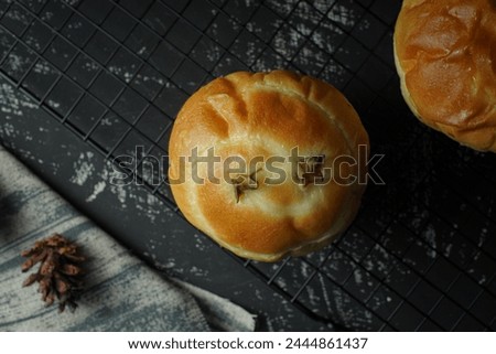 Sweet buns, pineapple jam filled cupcakes. On a cooling coaster, on a wooden table. Viewed from above