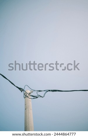 Electrical poles and cables standing tall against a clear sky