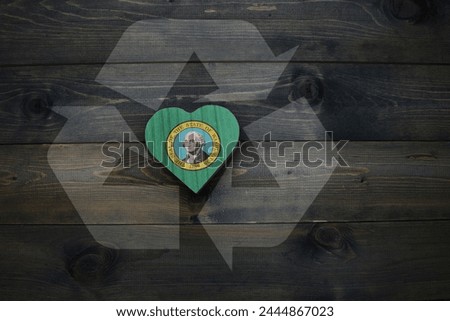 wooden heart with national flag of washington state near reduce, reuse and recycle sing on the wooden background. ecological concept