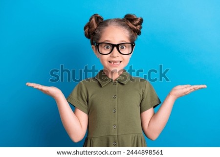 Photo of sweet schoolchild demonstrate two objects advert sale wear t shirt isolated blue shine color background