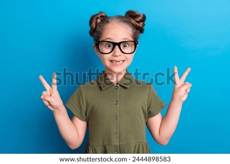Photo of sweet lovely schoolchild make v sign enjoy kindergarten wear t shirt isolated blue shine color background