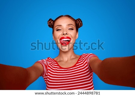 Self portrait of happy pretty positive girl shooting selfie on front camera with two hands having video-call with friend isolated on red background. Joy fun concept
