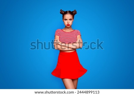Comedian humor joke concept. Portrait of grimacing funny capricious young woman model with bun hairstyle holding air in cheeks isolated on red background Royalty-Free Stock Photo #2444899113