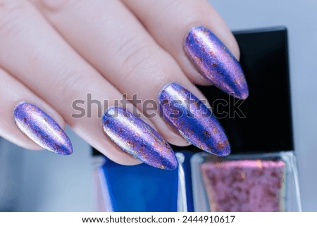 Female hand with long nails and a blue lilac color nail polish